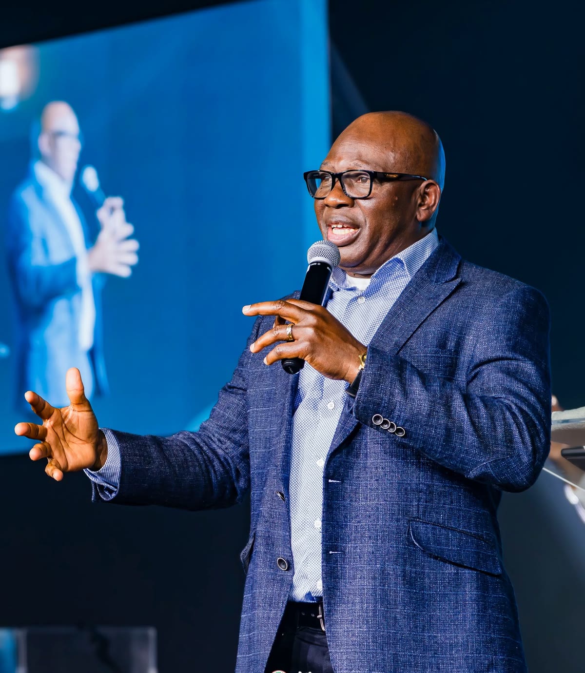 Pastor David Adeosun teaching the Word of God with a microphone at Kingdom Stars Assembly in Guelph